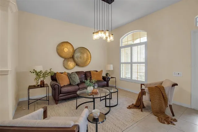 a living room with couches a dining table chair and a chandelier
