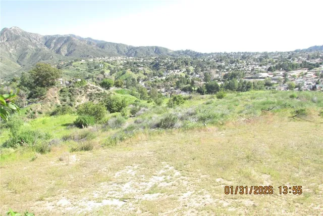 a view of a dry yard with mountains in the background