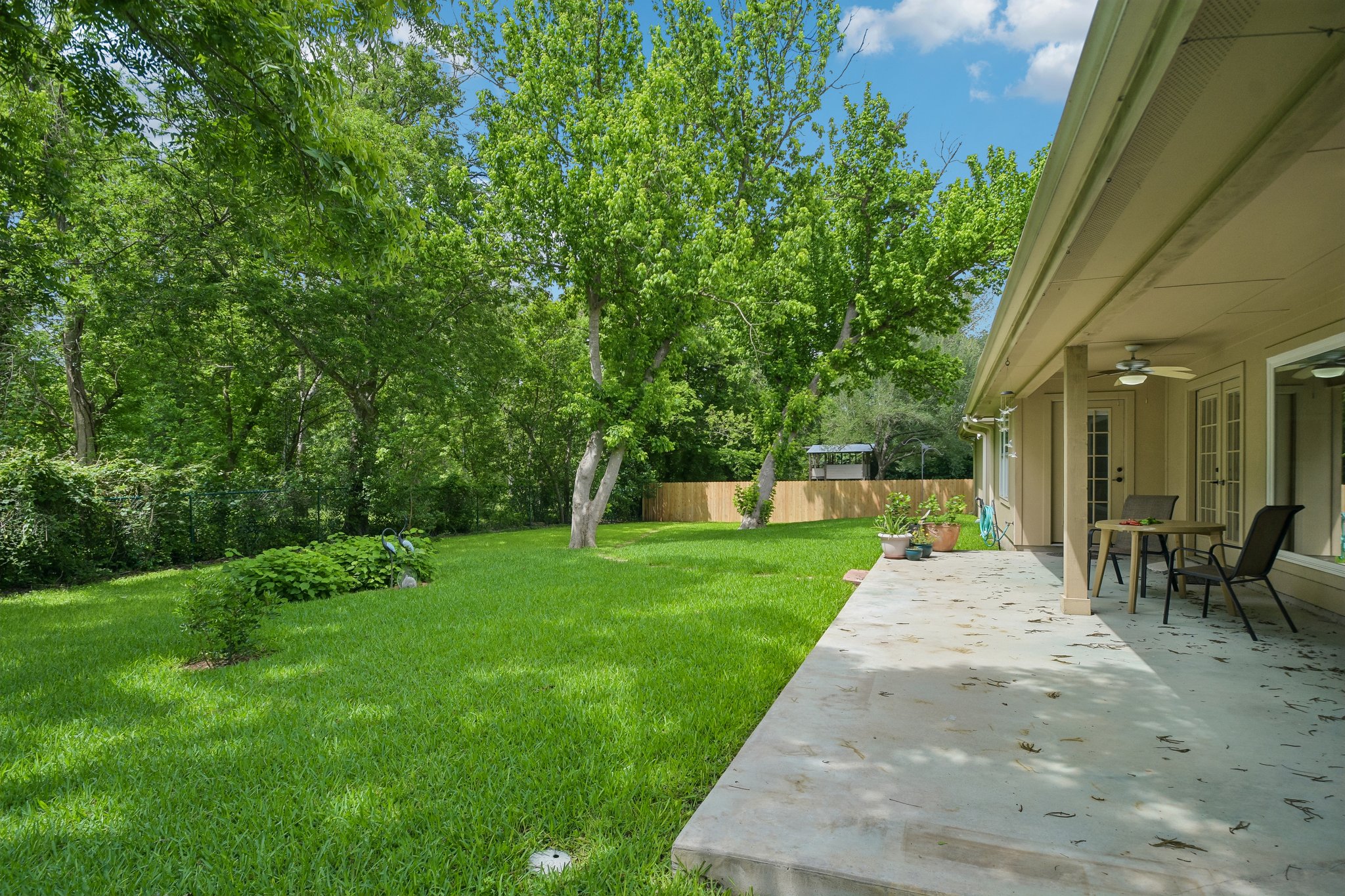 307 West 4th Street Elgin, TX 78621 - Photo 34 of 40 Expansive rear concrete patio featuring a ceiling fan and direct access to the interior via French doors