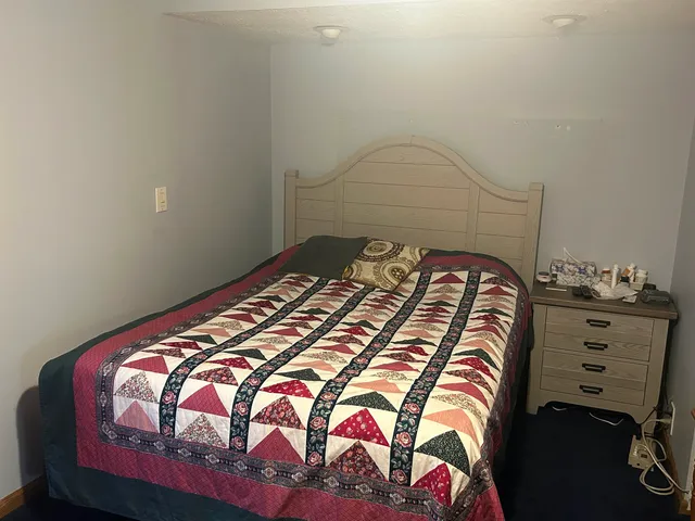 a bedroom with a bed and a painting on the wall