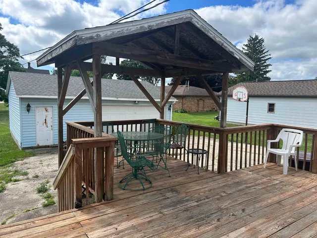 a view of a roof deck with table and chairs under an umbrella with wooden floor