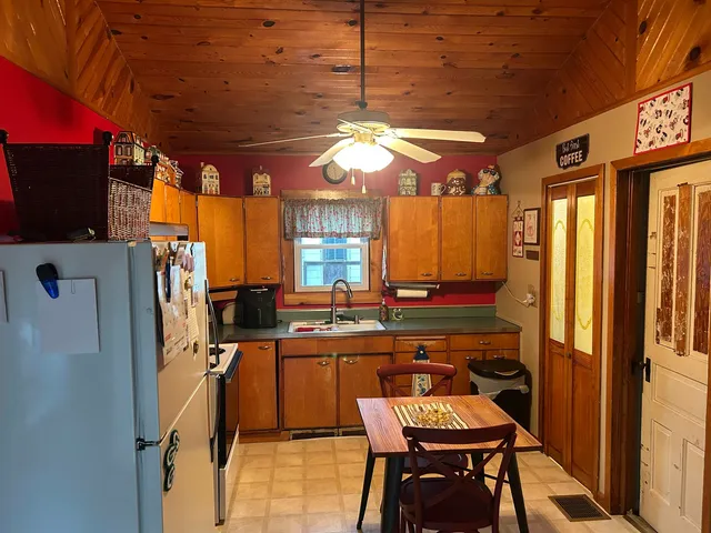 a view of a kitchen with a refrigerator dining table and chairs