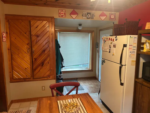a kitchen with stainless steel appliances a refrigerator and a wooden floor