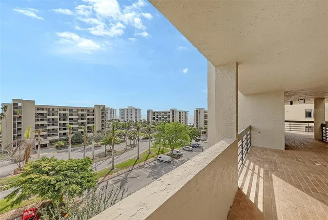 a view of patio with chairs and table under an umbrella with a barbeque