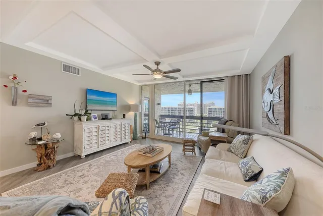 a living room with furniture a chandelier and a flat screen tv