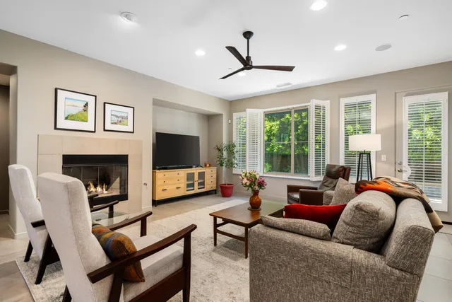 a living room with furniture a flat screen tv and a large window