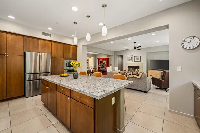 a kitchen with stainless steel appliances granite countertop a sink and a refrigerator