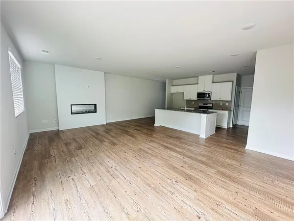 a kitchen with granite countertop a stove and a wooden floors