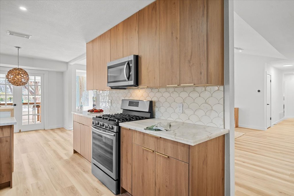 9223 Independence Loop Austin, TX 78748 - Photo 14 of 37 a kitchen with a stove a sink and a microwave