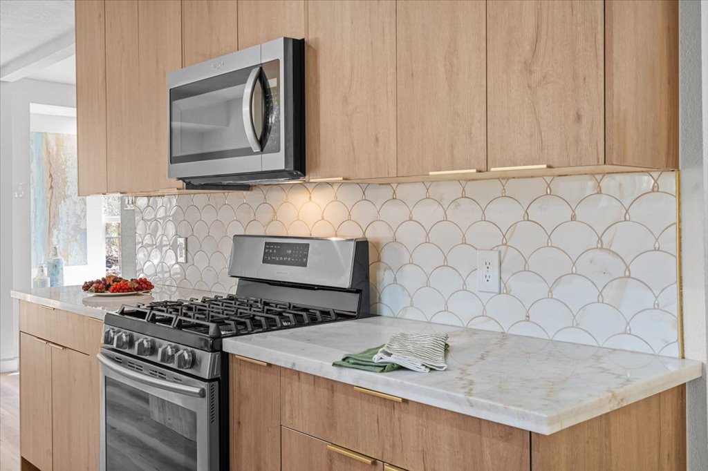 9223 Independence Loop Austin, TX 78748 - Photo 15 of 37 a kitchen with stainless steel appliances granite countertop white cabinets a stove top oven