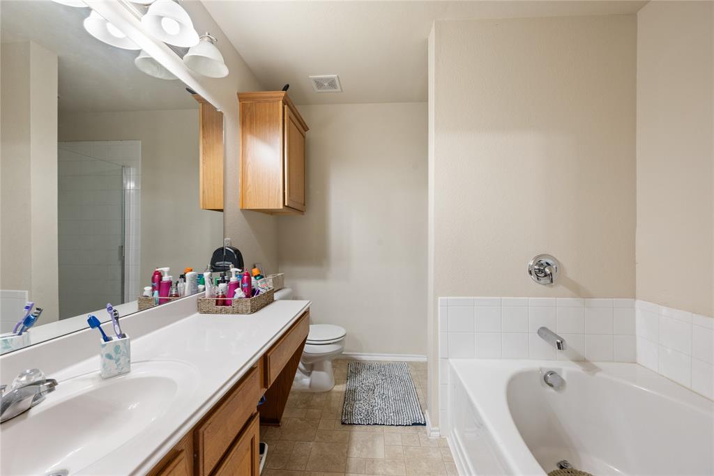 8613 King Ranch Drive Cross Roads, TX 76227 - Photo 16 of 25 a bathroom with a tub sink vanity and mirror