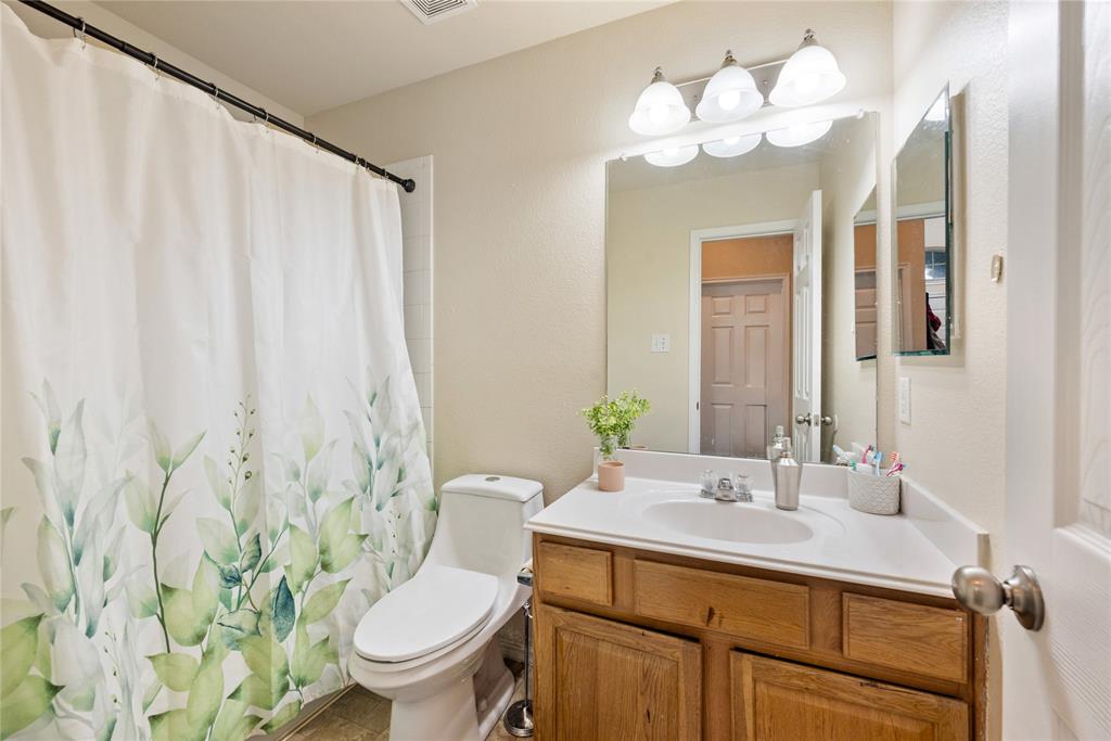 8613 King Ranch Drive Cross Roads, TX 76227 - Photo 19 of 25 a bathroom with a sink vanity mirror and toilet