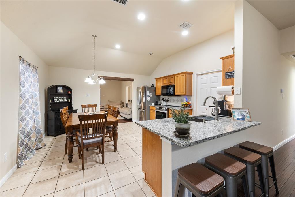 8613 King Ranch Drive Cross Roads, TX 76227 - Photo 6 of 25 a kitchen with a dining table chairs and white cabinets