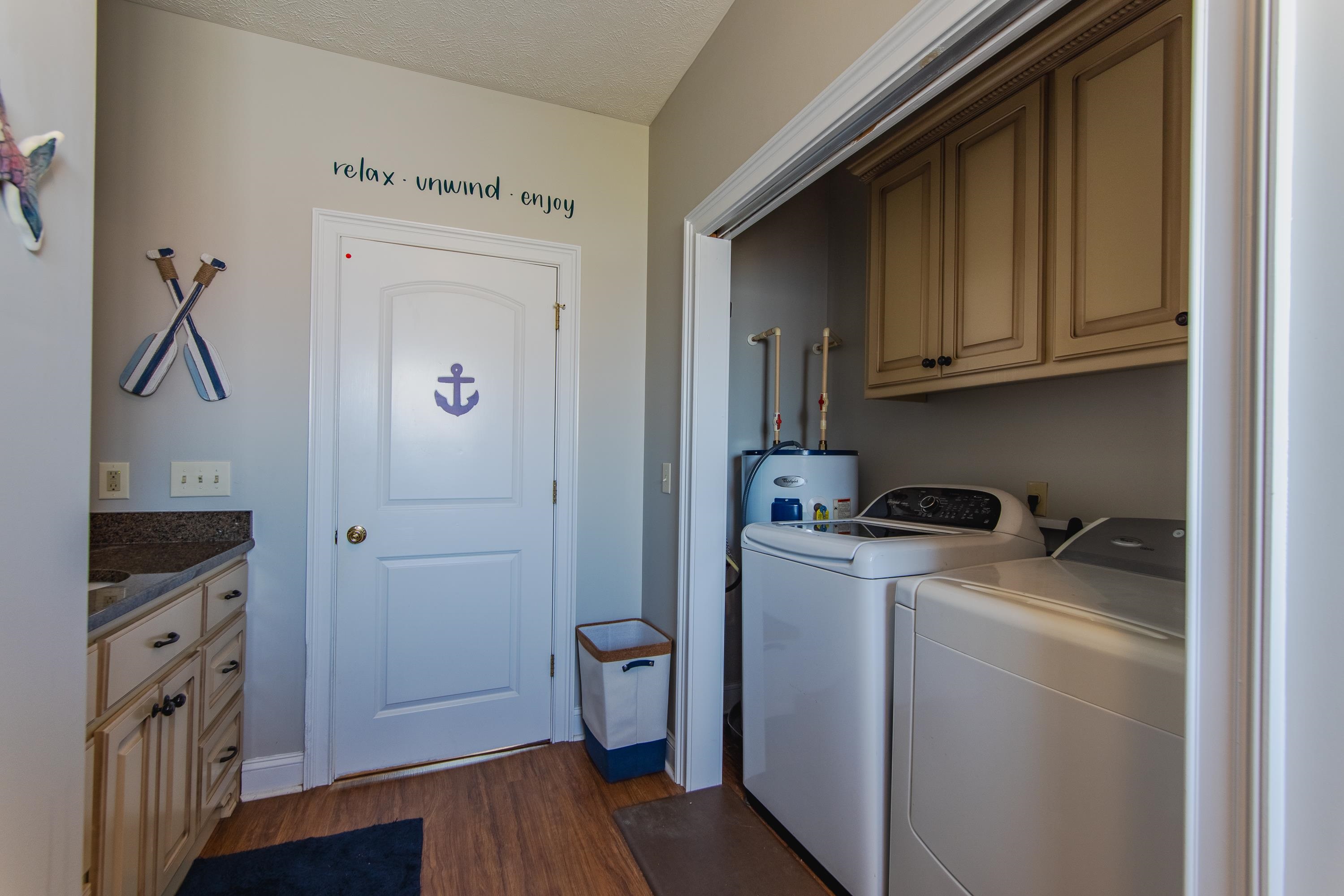 1111 Leaning Trees Lane Adamsville, TN 38310 - Photo 12 of 36 Clothes washing area featuring separate washer and dryer, dark hardwood / wood-style flooring, cabinets, and a textured ceiling