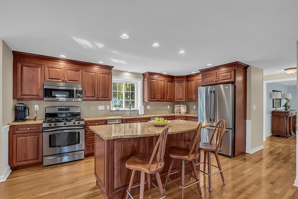 27 Sable Run Lane Methuen, MA 01844 - Photo 11 of 42 a kitchen with stainless steel appliances granite countertop a stove top oven a refrigerator a sink and chairs