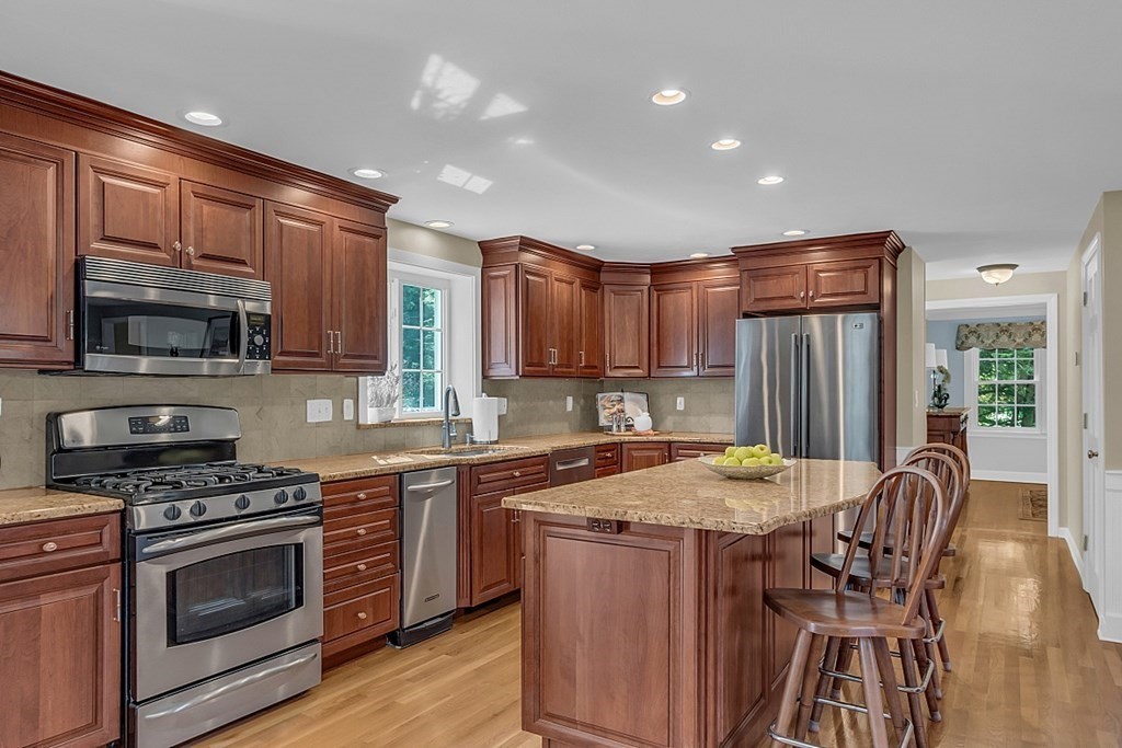 27 Sable Run Lane Methuen, MA 01844 - Photo 9 of 42 a kitchen with stainless steel appliances granite countertop a stove top oven a sink dishwasher a dining table and chairs with wooden floor