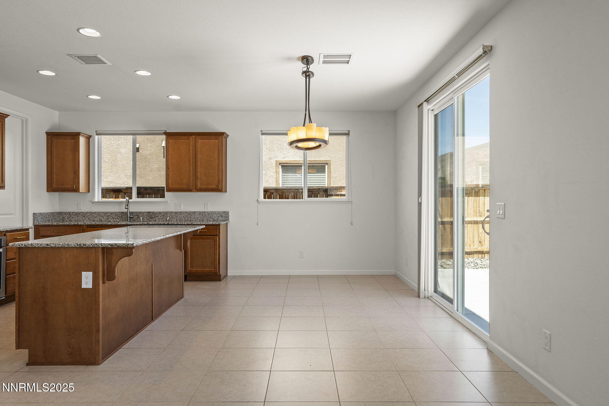 9610 Eventer Lane Reno, NV 89521 - Photo 14 of 38 a large kitchen with granite countertop a stove a sink a window and a counter top space