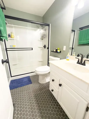a bathroom with a sink a toilet a tub and shower