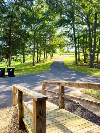 a front view of a house with a garden and trees