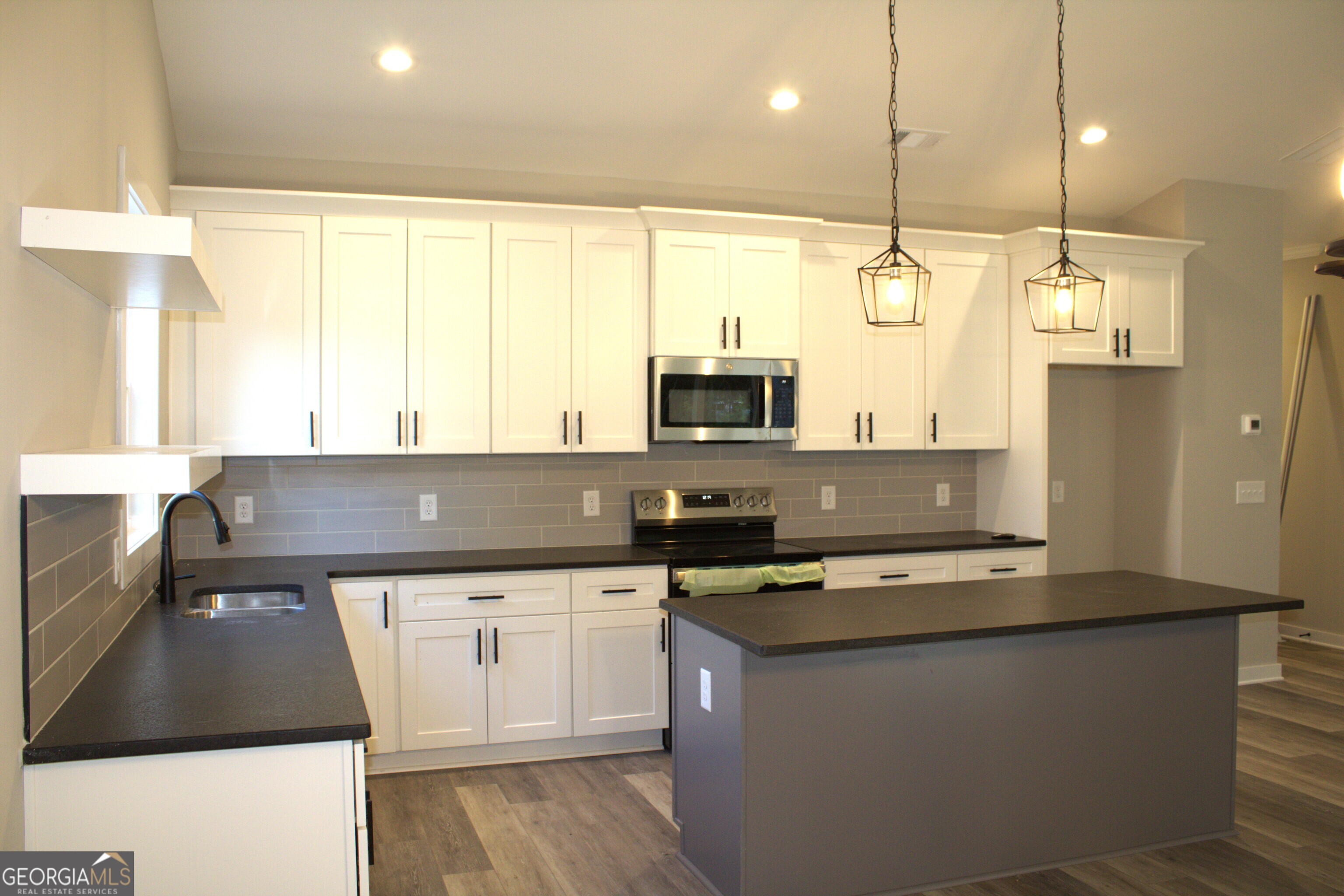 123 Fairview Street Hartwell, GA 30643 - Photo 7 of 23 a kitchen with stainless steel appliances a stove a sink a oven a counter top space and a window
