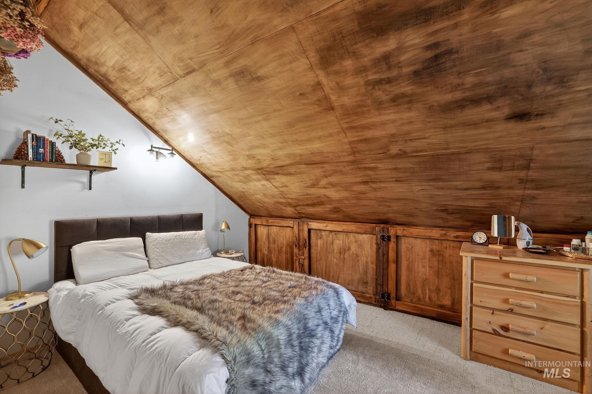 321 Secesh River Road McCall, ID 83638 - Photo 17 of 50 Attic room featuring a sloped wood-paneled ceiling and light-colored carpeting