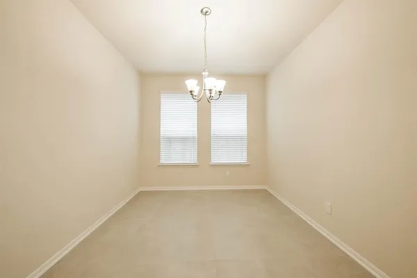 an empty room with windows and chandelier