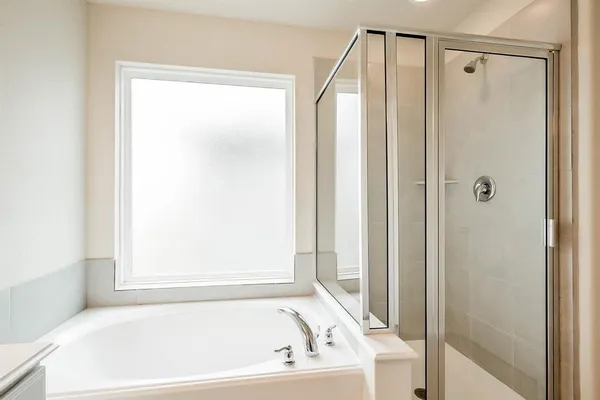 a white bath tub sitting next to a shower