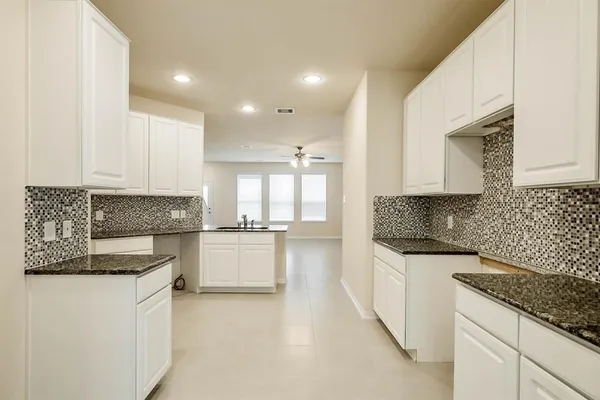 a kitchen with granite countertop white cabinets and white appliances