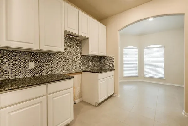 a kitchen with granite countertop white cabinets and sink
