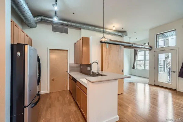 a kitchen with stainless steel appliances a refrigerator a stove and white cabinets