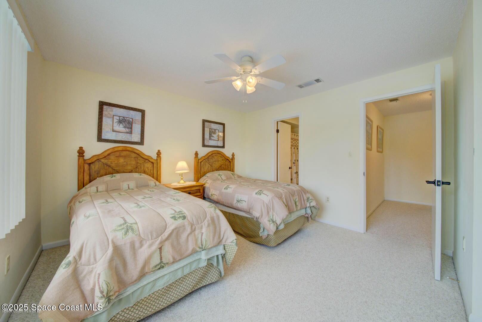 227 Augusta Way Melbourne, FL 32940 - Photo 26 of 35 a spacious bedroom with two beds and a chandelier