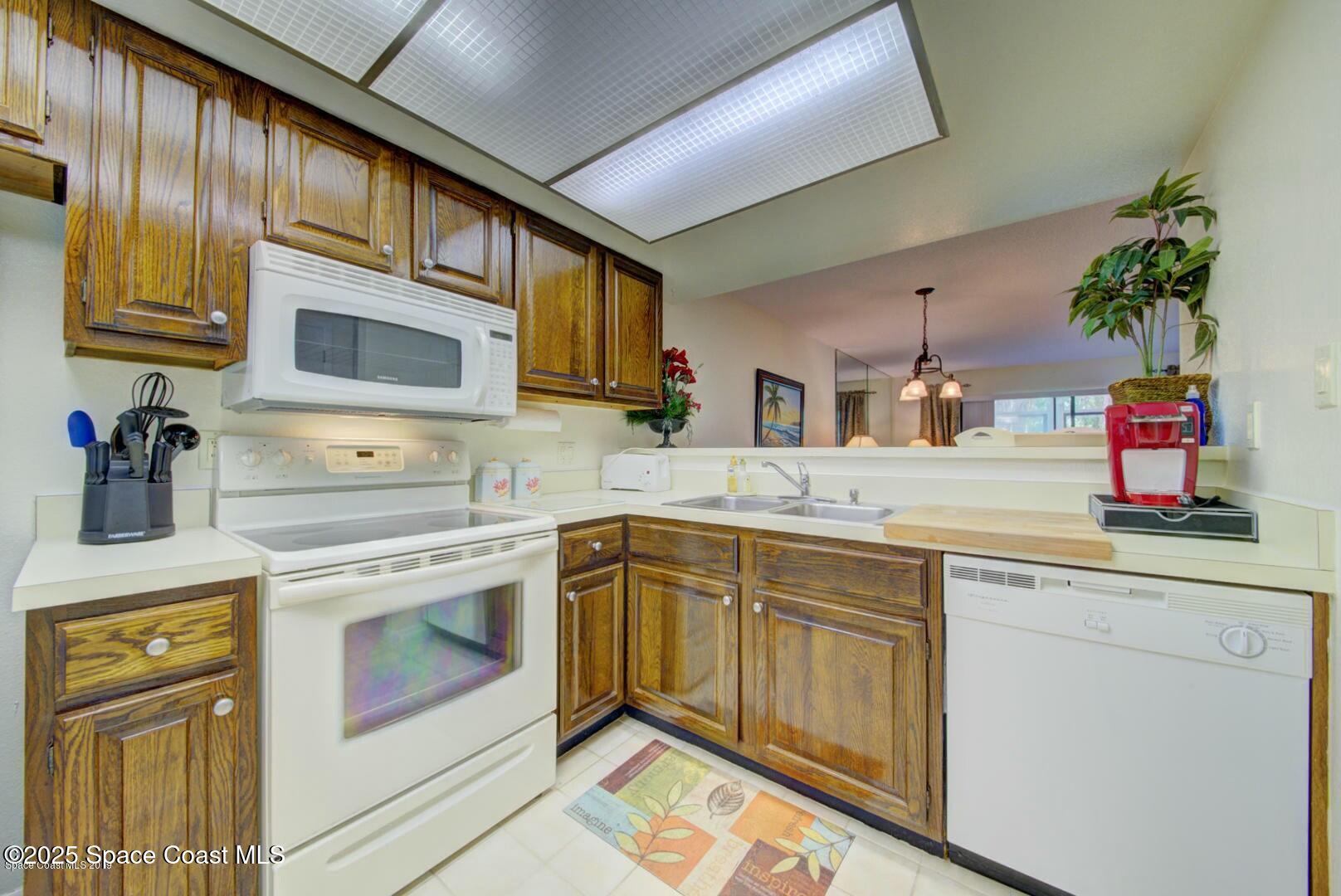 227 Augusta Way Melbourne, FL 32940 - Photo 9 of 35 a kitchen with stainless steel appliances granite countertop a sink stove and cabinets