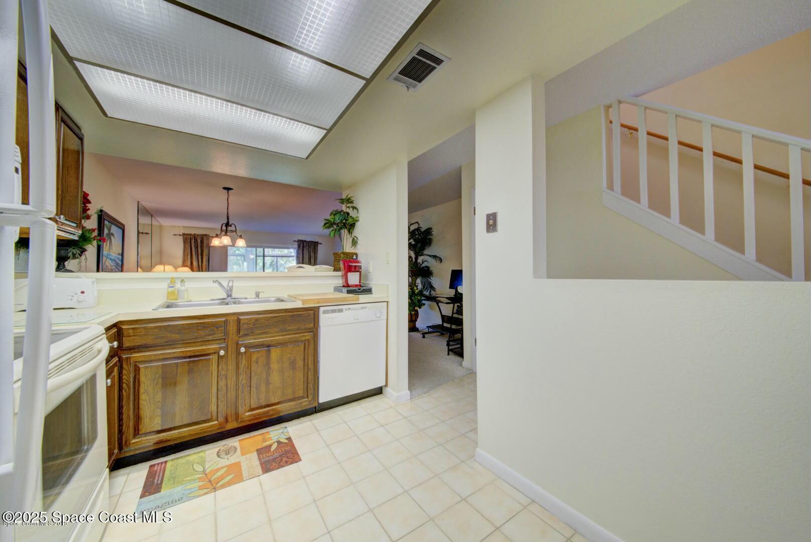 227 Augusta Way Melbourne, FL 32940 - Photo 10 of 35 a kitchen with stainless steel appliances granite countertop a sink and cabinets