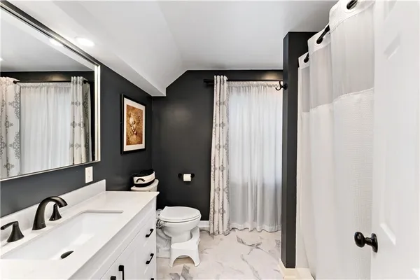 a bathroom with a sink mirror vanity and toilet
