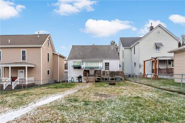 a view of a house with a big yard and large trees