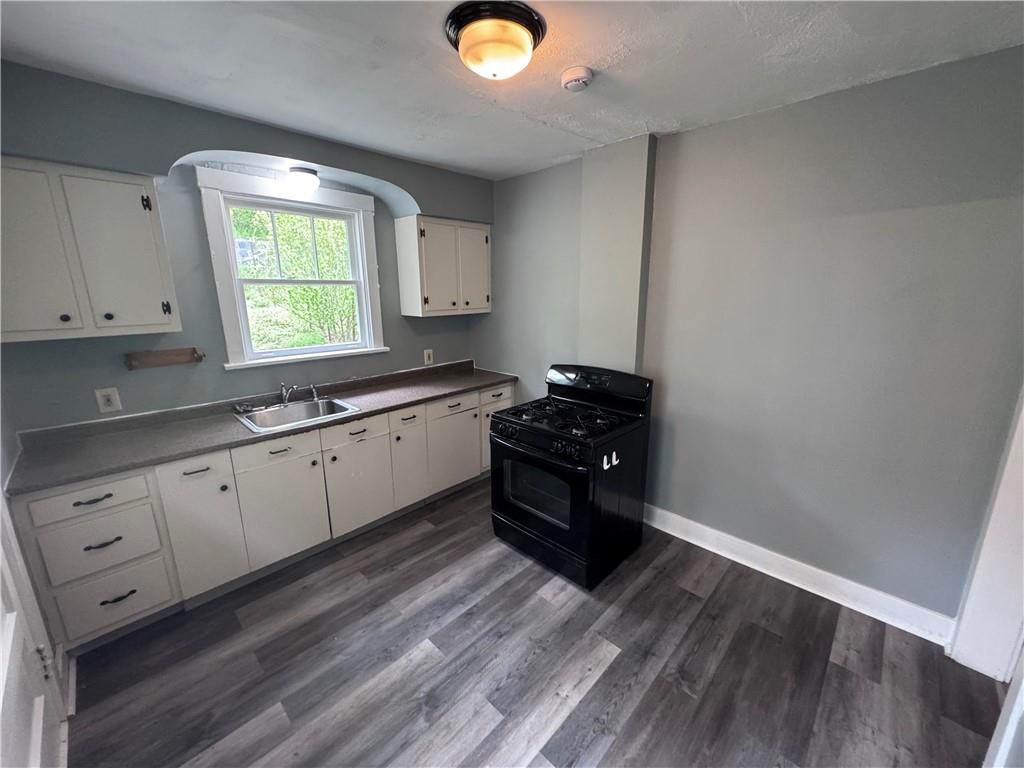 2733 Pyramid Avenue Pittsburgh, PA 15227 - Photo 8 of 14 a kitchen with granite countertop a stove a sink and a window
