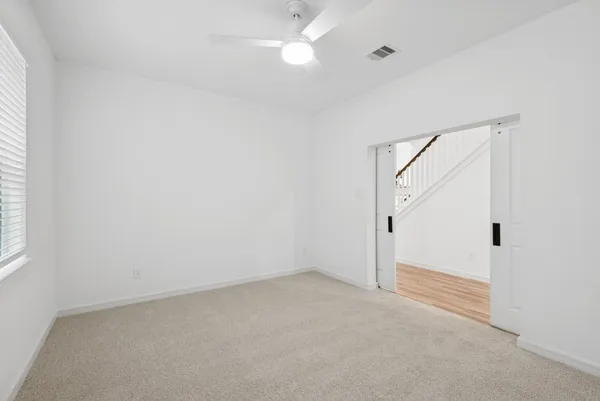an empty room with a ceiling fan and a window