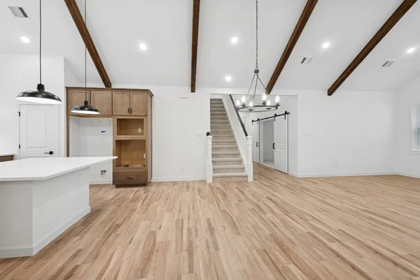 a view of a kitchen with wooden floor and electronic appliances