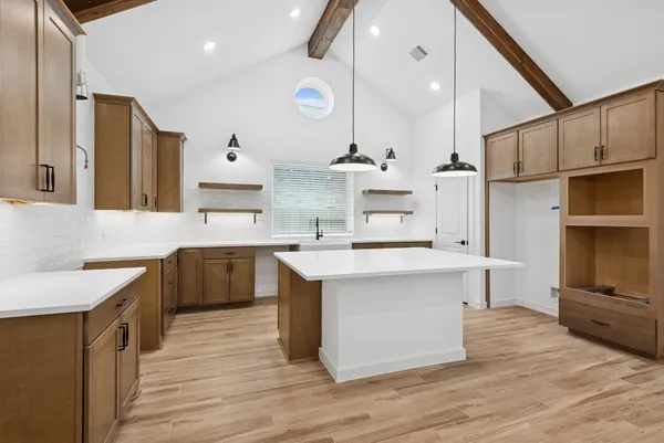 a large kitchen with stainless steel appliances kitchen island granite countertop a sink a stove and a refrigerator