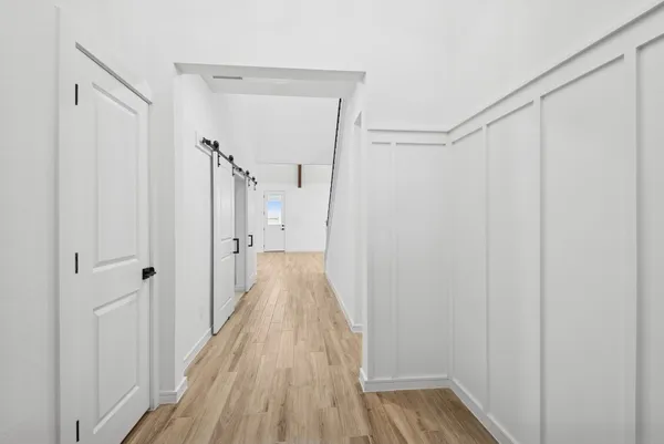 a view of a hallway with wooden floor and closet