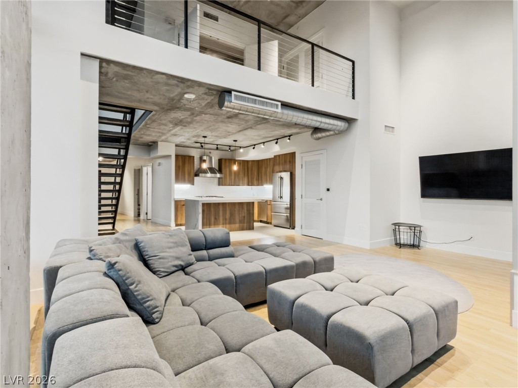 360 East Desert Inn Road, Unit 607 Las Vegas, NV 89109 - Photo 7 of 55 Lofty ceilings and a vibrant living space seamlessly flow into a modern kitchen, ideal for urban living.