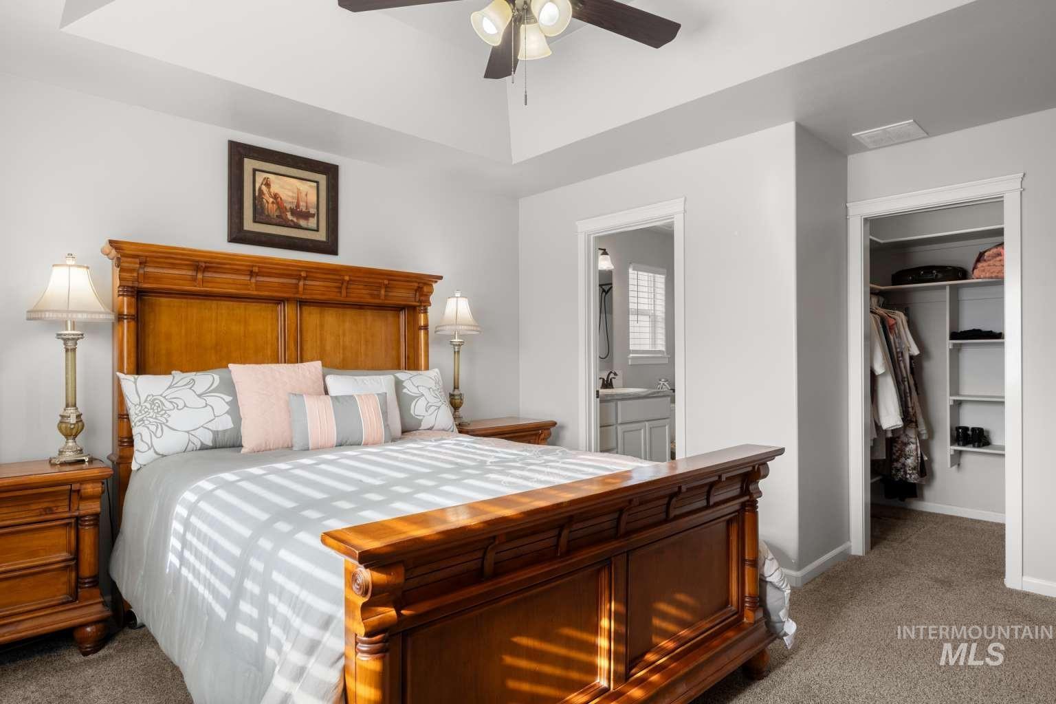 521 East 15th Street Rupert, ID 83350 - Photo 13 of 21 Carpeted bedroom featuring a spacious closet, a ceiling fan, and connected bathroom