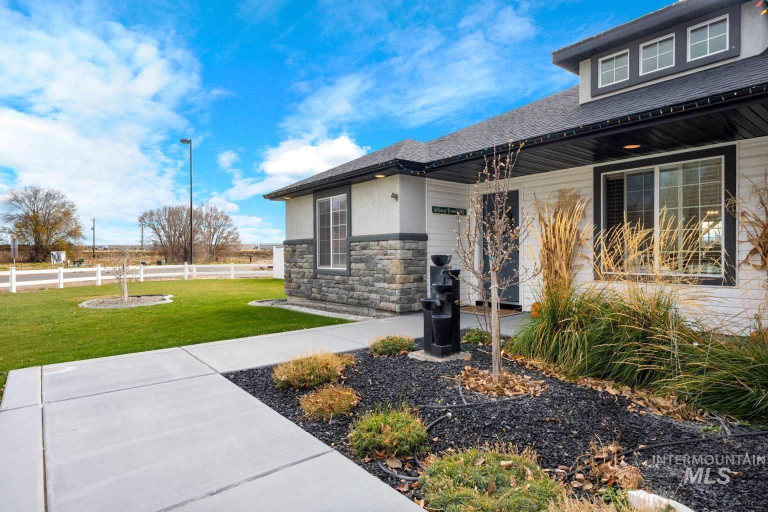 521 East 15th Street Rupert, ID 83350 - Photo 4 of 21 View of exterior entry featuring stone siding, roof with shingles, and stucco siding