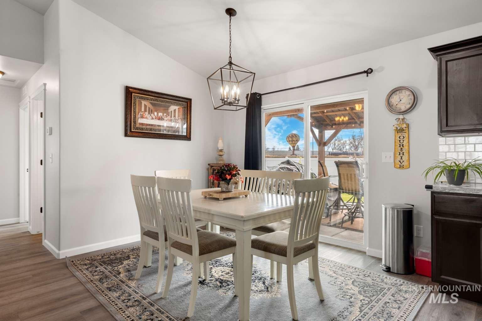 521 East 15th Street Rupert, ID 83350 - Photo 6 of 21 Dining room featuring light wood-style flooring, a chandelier, and vaulted ceiling
