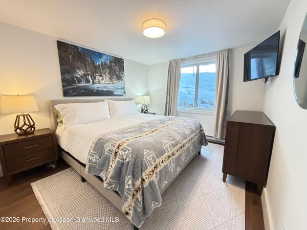 a bedroom with a bed and a painting on the wall