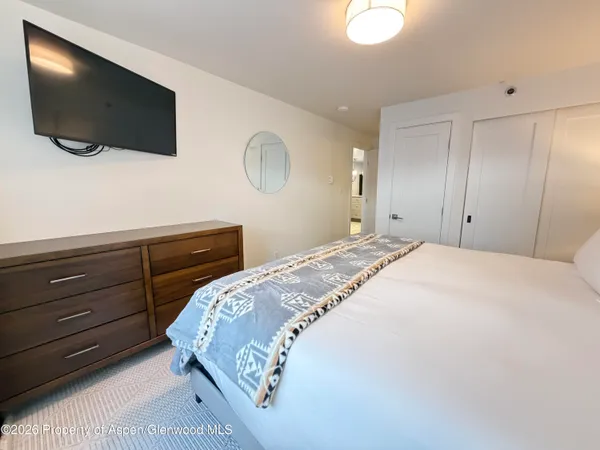 a bedroom with a bed and a flat screen tv