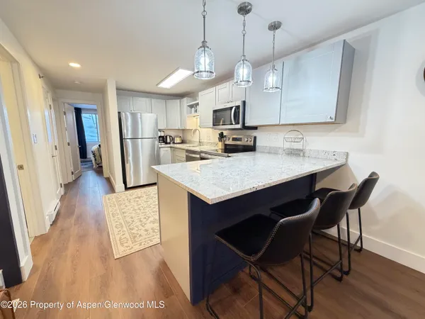 a kitchen with a table chairs refrigerator and microwave