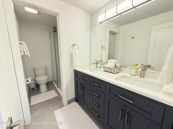 a spacious bathroom with a double vanity sink toilet and a mirror