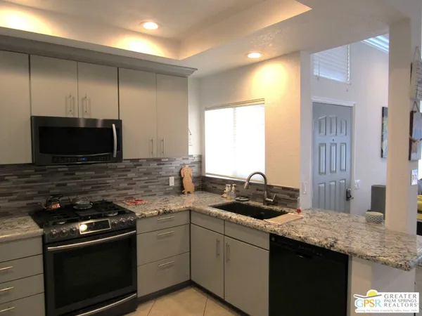 a kitchen with a sink stove and microwave