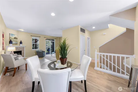 a dining room with furniture potted plants and wooden floor